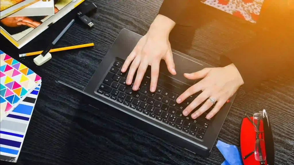 women typing on a laptop